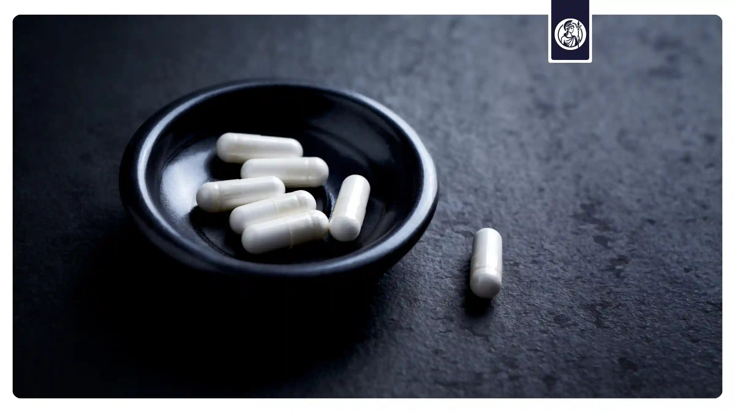 Weiße Kapseln in einer schwarzen Schale – Symbol für die Reinheit, Qualität und geprüfte Sicherheit der Longevity-Supplements von Minerva-Vita.