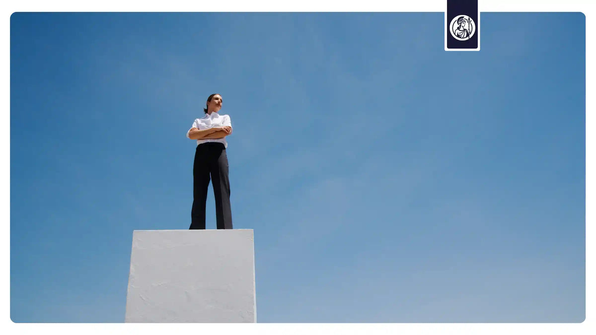 Frau auf einem Podest vor blauem Himmel als Symbol für Überblick, klare Entscheidungen und die Wahl zwischen All-in-One Supplement und Einzelkapseln.