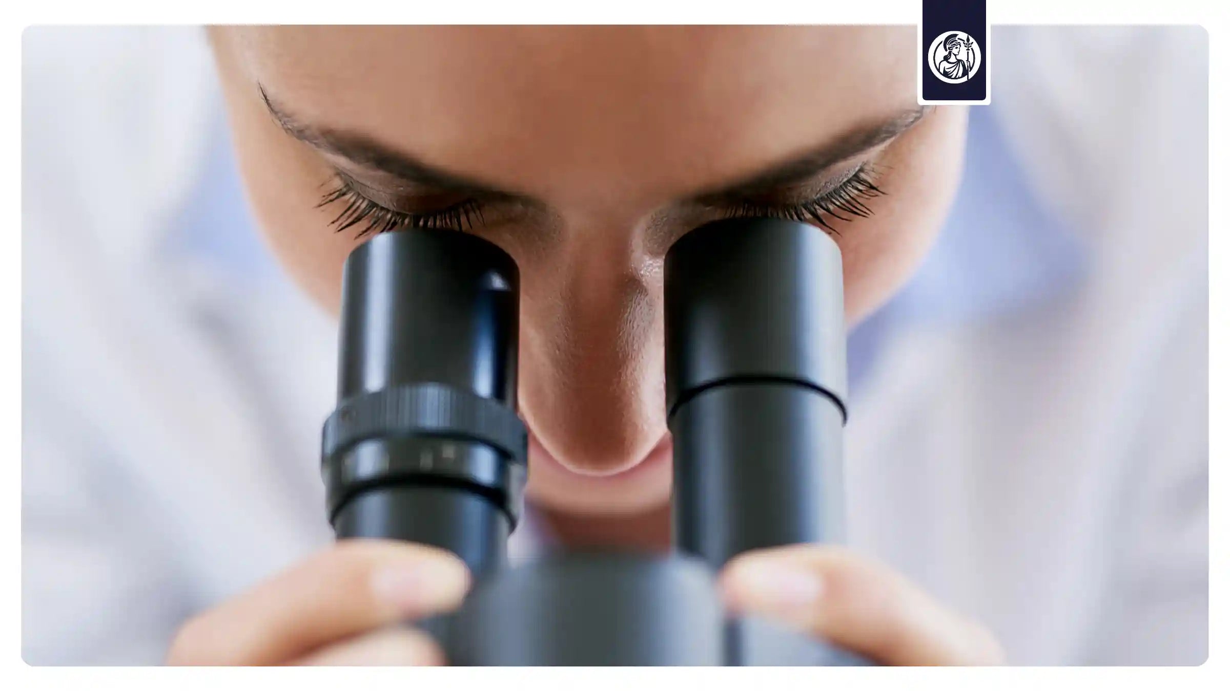 Ärztin sieht durch ein Mikroskop