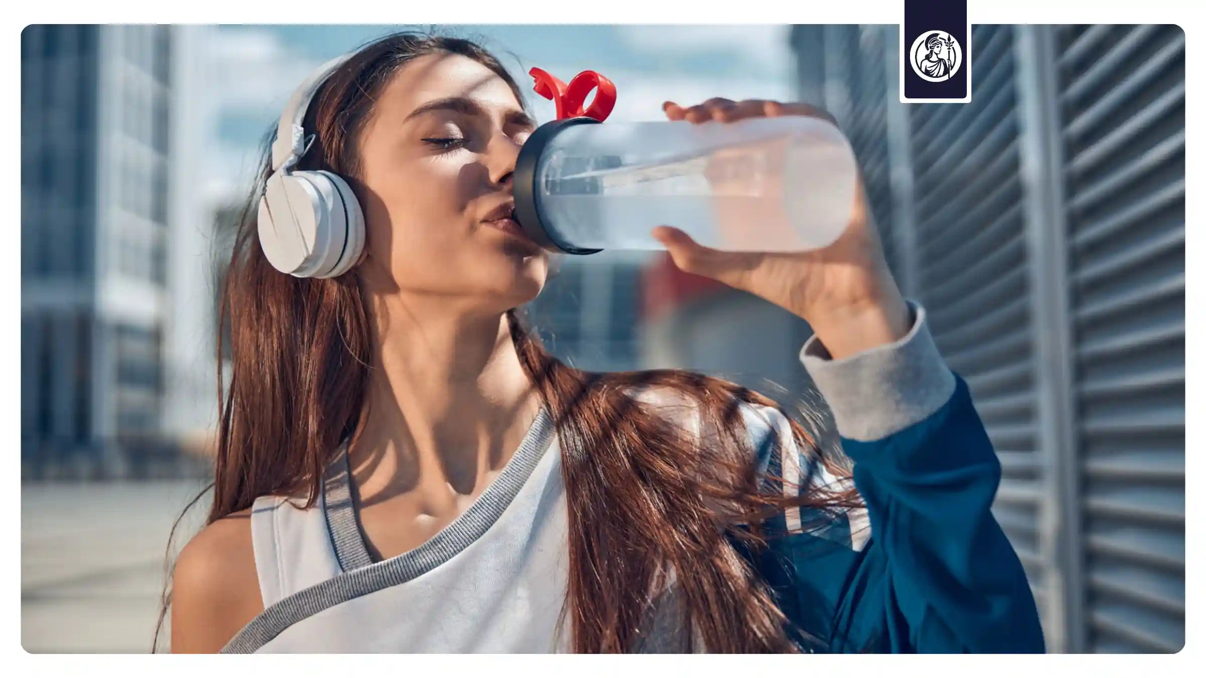 Sportliche Frau trinkt aus Sportflasche