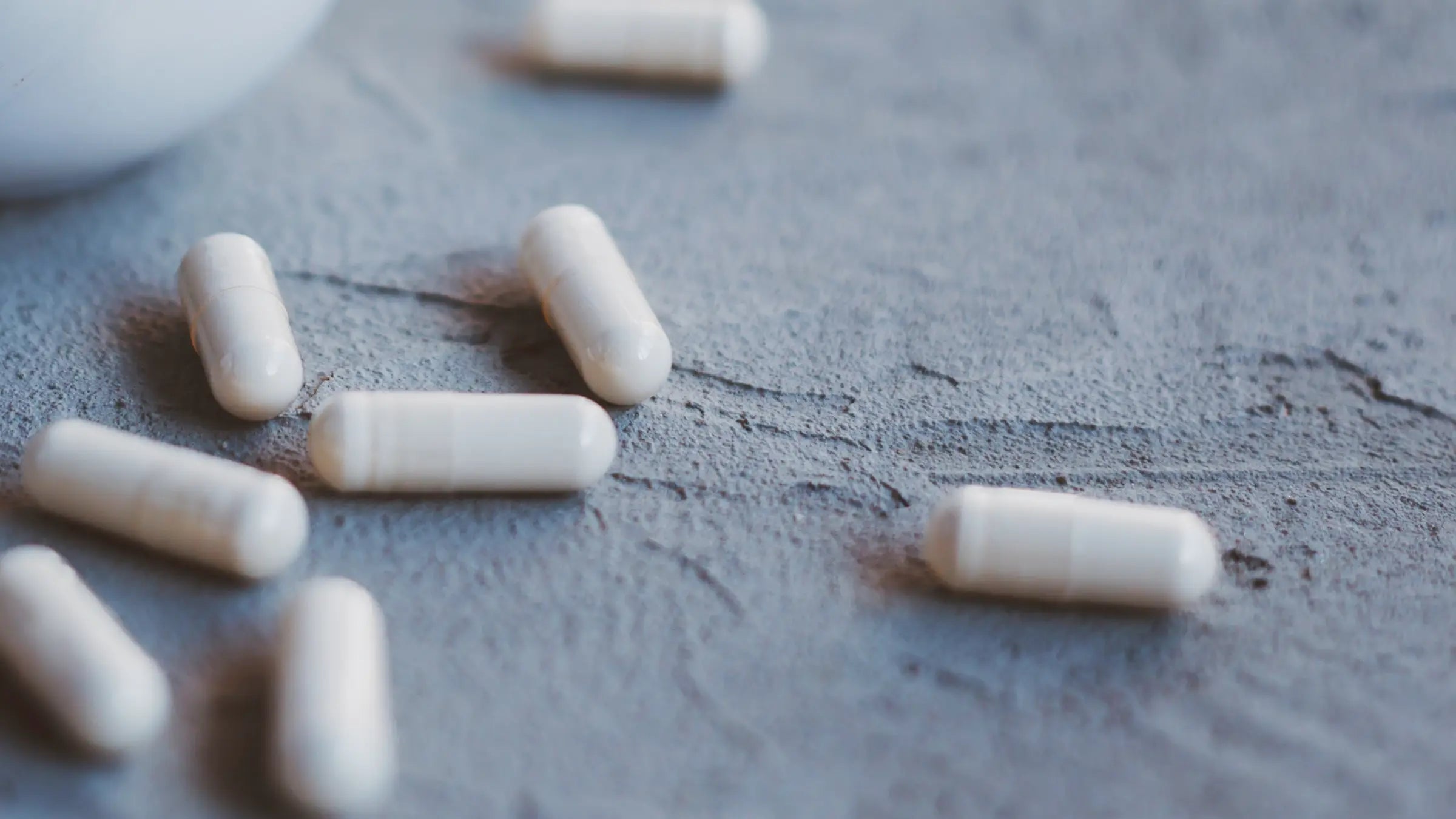 weiße Kapseln auf hellblauen Hintergrund